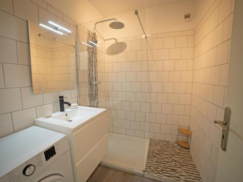 a bathroom with a sink and a washing machine at appartement du Bellay in Sarlat-la-Canéda