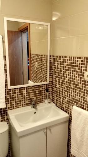 a bathroom with a sink and a toilet and a mirror at Casa do Pelourinho - T0 in Loriga