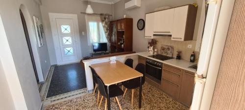 uma cozinha com uma mesa de madeira e uma sala de jantar em Μοντέρνα εξοχική κατοικία στην Κωμη em Kómi