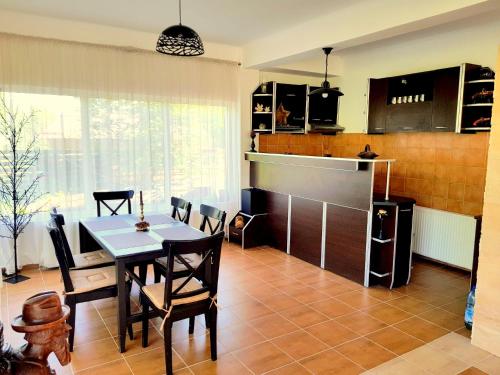a kitchen and dining room with a table and chairs at VILA VIBRANT in Bran