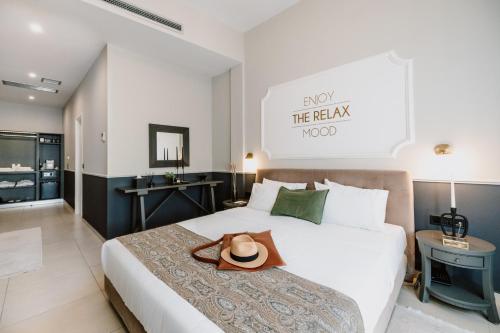 una habitación de hotel con una cama con sombrero en The Mood Luxury Rooms, en Tesalónica