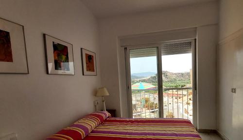 a bedroom with a bed and a window with an umbrella at VILLA PANORAMA El Mediterráneo a tus pies. in Salobreña