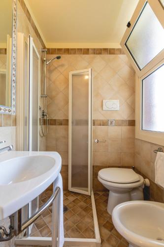 a bathroom with a toilet and a sink and a shower at Hotel Loretta & Dependance in Cervia
