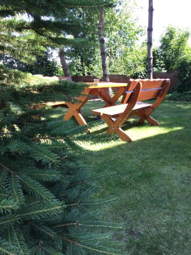 a wooden picnic table and bench in a park at Agroturystyka Krajno - Zagórze in Krajno-Zagórze