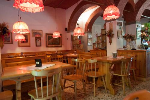um restaurante com mesas e cadeiras de madeira e lustres em Tre Fiumi em Ronta