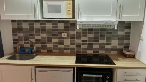 a kitchen with a sink and a stove top oven at Casa do Pelourinho - T1 in Loriga