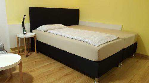 ein großes Bett mit schwarzem Kopfteil in einem Zimmer in der Unterkunft Apartment Metzingen City in Metzingen