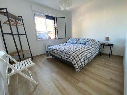 sypialnia z łóżkiem i drewnianą podłogą w obiekcie DOMUS AUREA Maison Dorée w mieście Jard-sur-Mer