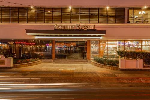 un magasin devant un bâtiment la nuit dans l'établissement The Avenue Regent, à Cochin