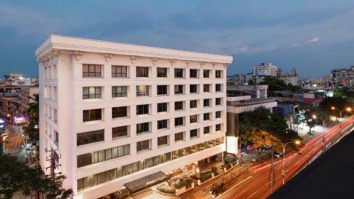 a tall white building in a city at night at The Avenue Regent in Cochin