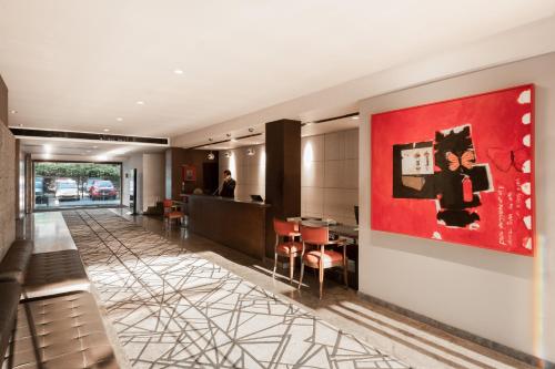 a lobby of a hotel with a red painting on the wall at The Avenue Regent in Cochin