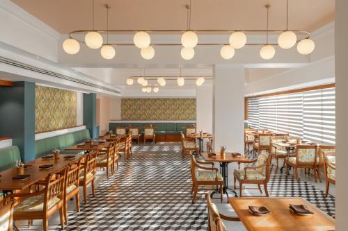 a dining room with wooden tables and chairs at The Avenue Regent in Cochin
