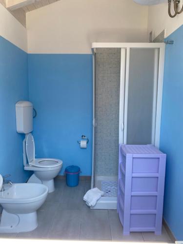y baño azul con aseo y ducha. en Casa azzurra, en Reitani
