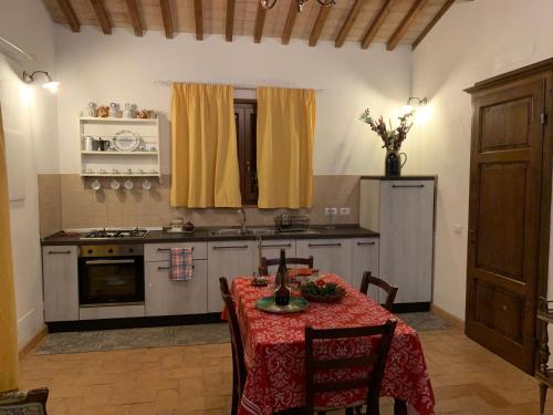 a kitchen with a table with a red table cloth at Il Casale delle Mura in Saturnia