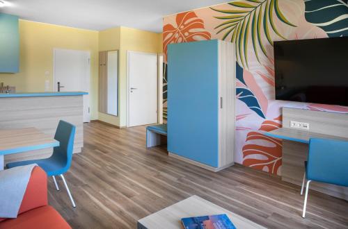un soggiorno con TV, tavolo e sedie di Hi5-Hotel Seiersberg a Windorf