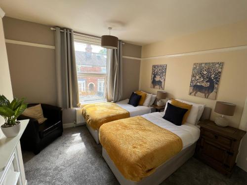 a hotel room with two beds and a window at Comfortable King Bed - Location - Contractors - Family - Parking in Bedford