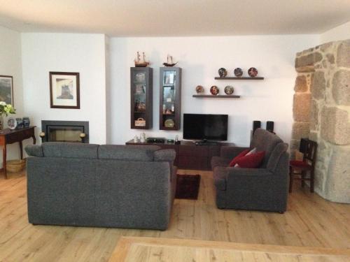 a living room with two couches and a tv at Casa Da Trigueira in Santa Eugénia