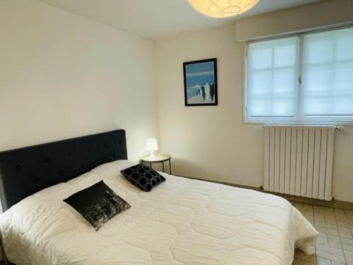 une chambre avec un grand lit blanc avec deux oreillers dans l'établissement Appartement cosy, jardin privé, 100m de la plage, Côte de Granit Rose - FR-1-542-10, à Trégastel