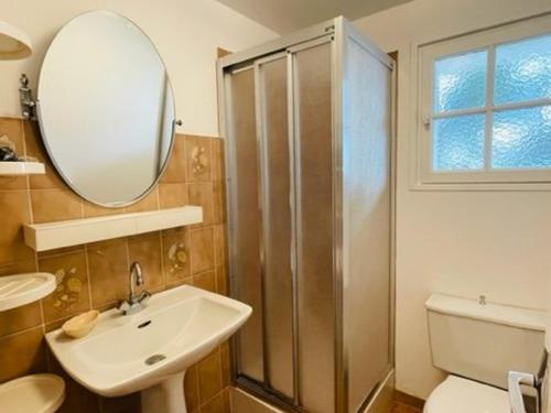 une salle de bain avec une douche, un lavabo et un miroir dans l'établissement Appartement cosy, jardin privé, 100m de la plage, Côte de Granit Rose - FR-1-542-10, à Trégastel