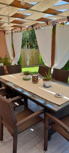 een eettafel met stoelen en een parasol bij Villa Oneiropagida in Preveza