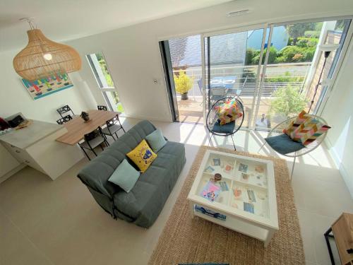 un salon avec un canapé et une table dans l'établissement Duplex lumineux à Bénodet: plage et thalasso à pied, terrasse, parking et abri vélo inclus - FR-1-481-117, à Bénodet