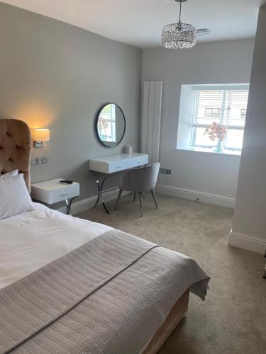 a bedroom with a bed and a desk and a chair at Black Mountain Lodge in Glasbury