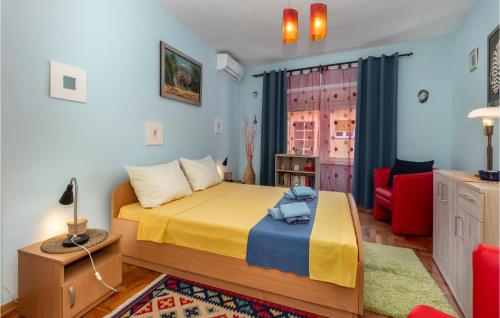 ein Schlafzimmer mit einem Bett und einem roten Stuhl in der Unterkunft 3 Bedroom Nice Home In Crikvenica in Crikvenica
