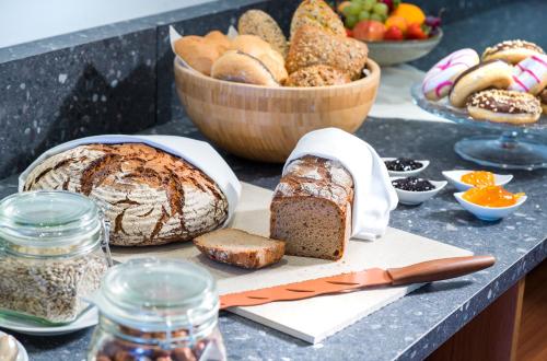a table with bread and a bowl of fruit at Hi5-Hotel Seiersberg in Windorf