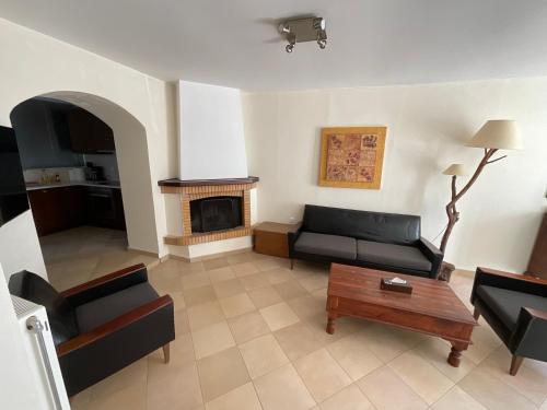 een woonkamer met een bank en een open haard bij Giota’s House in Néa Koróni