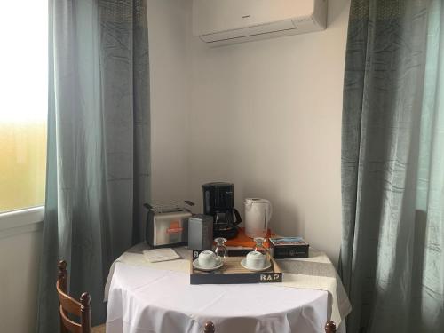 uma mesa com uma toalha de mesa branca e um liquidificador em Casa Rosalinda em Figari