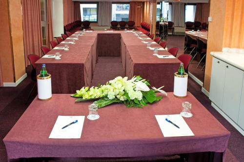a long table with tables in a room with chairs at Hotel Giberti & Spa in Verona
