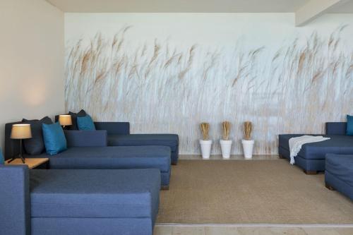 a living room with blue couches and a wall at Hotel Linde in Maria Wörth