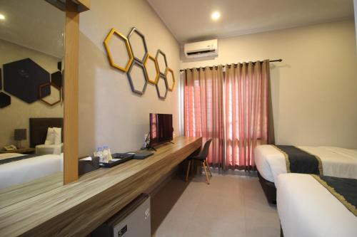 a hotel room with a desk and a bed at Casananta Seminyak in Seminyak