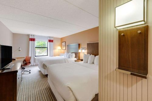 a hotel room with two beds and a television at The Crossroads Hotel - Newburgh in Newburgh