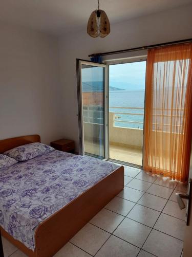 a bedroom with a bed and a view of the ocean at Apartmani Karla in Dugi Rat