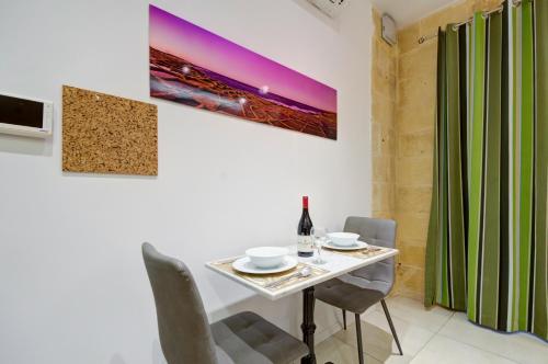 a dining room with a white table and chairs at Tritoni Harbour suites - Valletta in Valletta