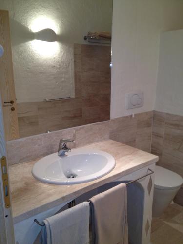 a bathroom with a sink and a toilet at Antica Dimora La Corona in San Pantaleo