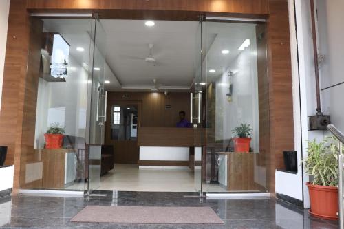 an office lobby with glass doors and potted plants at Hotel New Samrat in Aurangabad