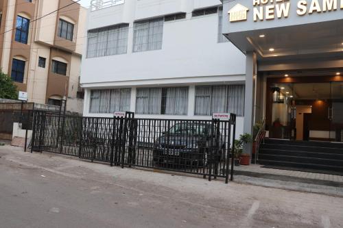 a black fence in front of a new sanity building at Hotel New Samrat in Aurangabad