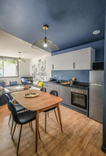 une cuisine avec une table en bois et une salle à manger dans l'établissement L'élégant de fourvière, à Lyon