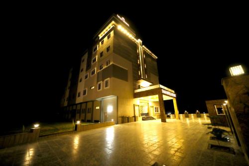 un edificio alto con luces encendidas por la noche en The Sky Imperial - Shahi Hotels & Resort, en Nathdwara