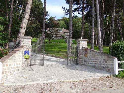 a stone fence with a gate in a park at Chambres d'Hôtes Le Grismoustier in Veulettes-sur-Mer