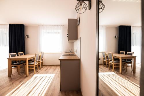 een keuken en eetkamer met een tafel en stoelen bij Apartamenty Henry in Łeba