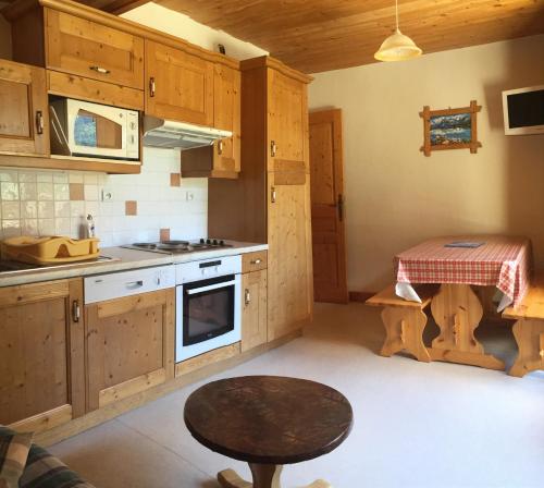 une cuisine avec des armoires en bois et une table à l'intérieur dans l'établissement Appartement Montana 8, à Pralognan-la-Vanoise