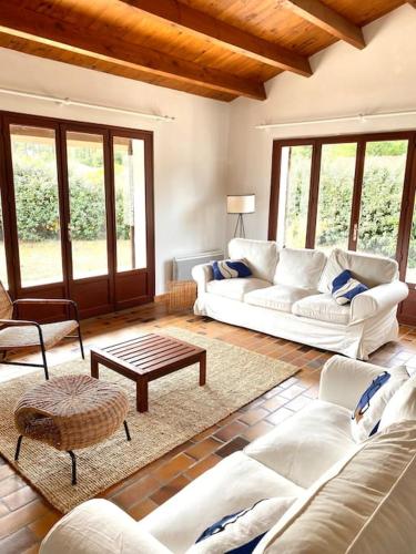 un salon avec des canapés blancs et une table dans l'établissement Magnifique villa avec piscine à La Palmyre, aux Mathes