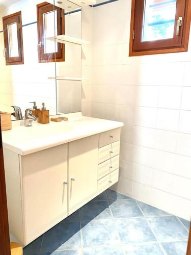 une salle de bain blanche avec un lavabo et un miroir dans l'établissement Magnifique villa avec piscine à La Palmyre, aux Mathes