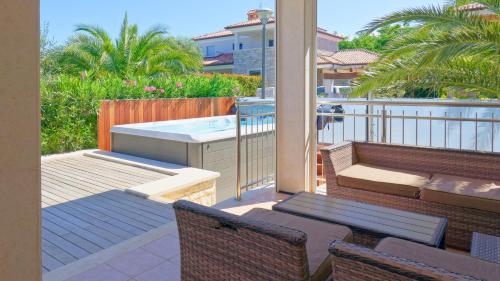 balcón con bañera de hidromasaje y patio con sillas en Villa Jazzbina, en Savudrija