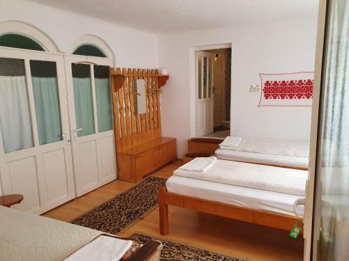 a small room with two beds and a door at Rózsa Panzió in Rimetea