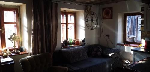 sala de estar con sofá azul y 2 ventanas en Útulný domek s malou zahrádkou, en Dačice
