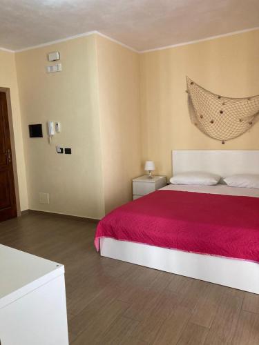 um quarto com uma cama grande e um cobertor vermelho em Casa di Vigata em Licata